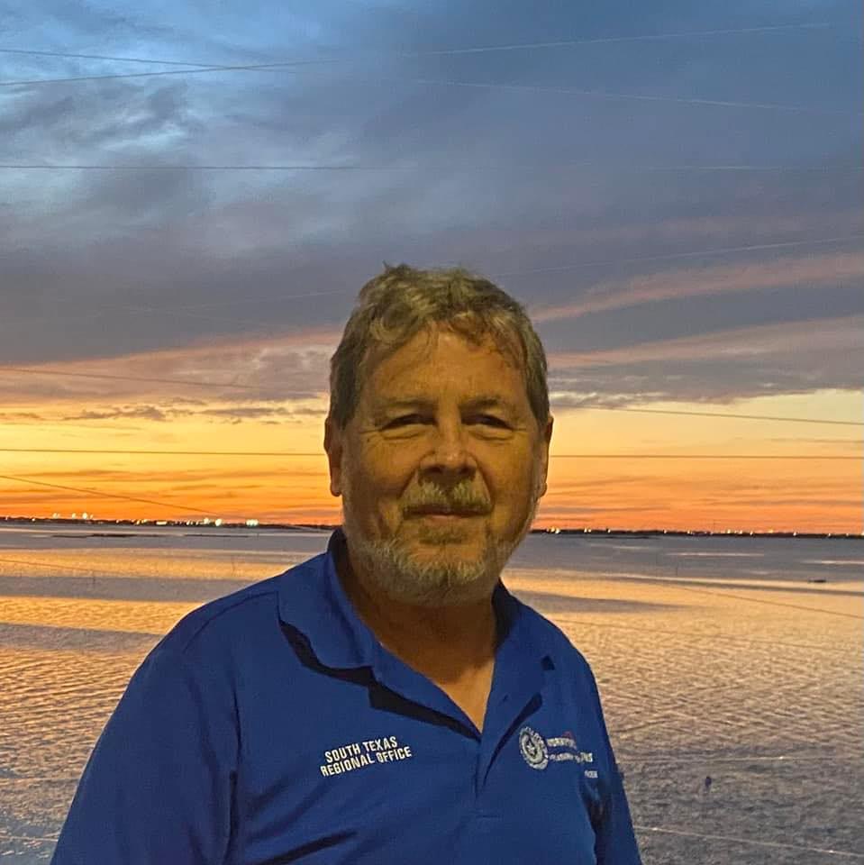 Bryan smiles in front of a beautiful sunset